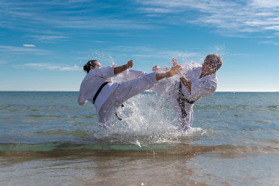 Dos practicantes de artes marciales entre el agua y las salpicaduras