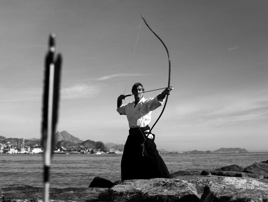 Arquero apuntando junto al mar