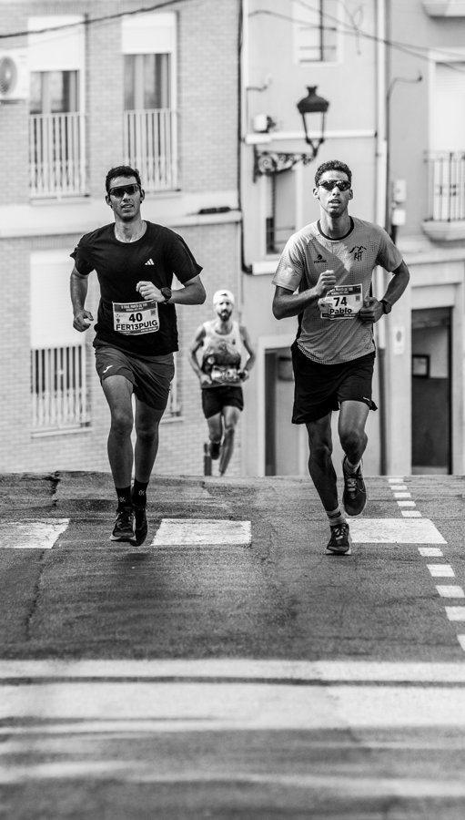 Corredores por una calle en blanco y negro