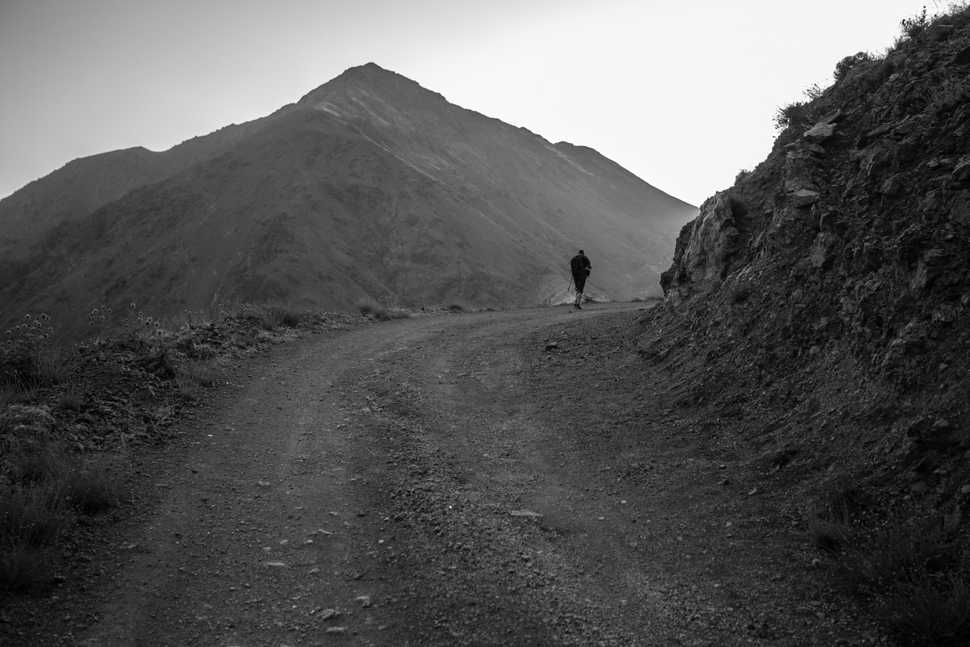 Un caminante recorre un sendero de montaña, fotografía en blanco y negro