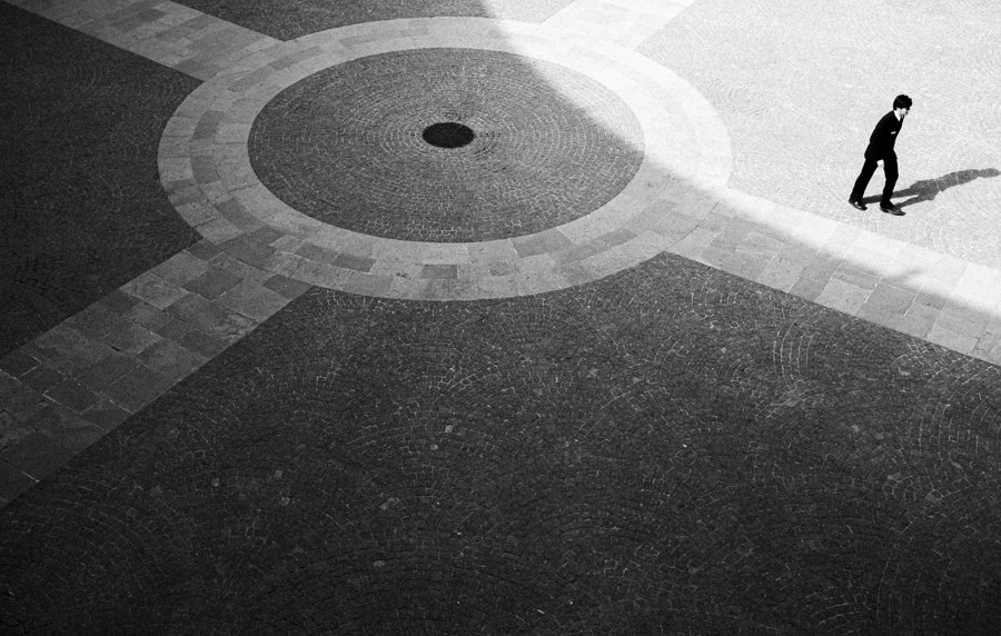 Una persona cruza una plaza de formas circulares
