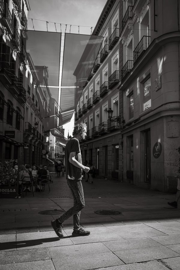 Un peatón cruza una calle entre edificios
