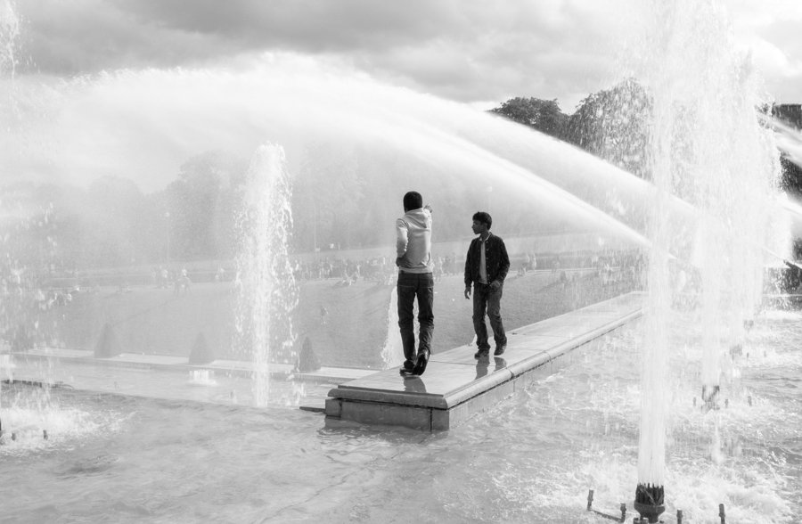 Dos personas junto a los chorros de una fuente