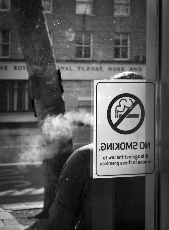 Humo junto a una señal de prohibido fumar